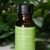 A bottle of pure bergamot essential oil with fresh bergamot fruit and leaves in the background.